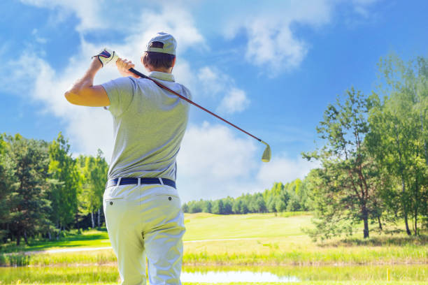 Golfer hits an fairway shot towards the club house. Golfer hits an fairway shot towards the club house t shirt caucasian photography color image stock pictures, royalty-free photos & images
