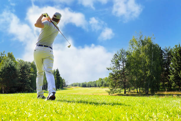 Golfer hitting golf shot with club on course while on summer vacation. Golfer hitting golf shot with club on course while on summer vacation golfer swinging club stock pictures, royalty-free photos & images