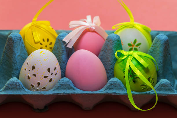Easter egg as decoration. The Easter egg is in the egg carton. The background is monochrome.