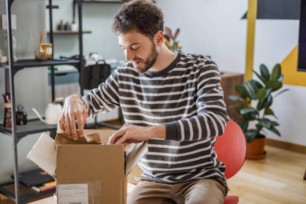 istock Young man unpacks the box with online ordered items 1371505765