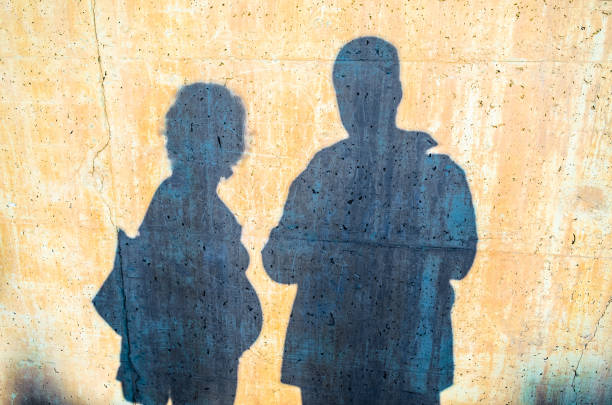 Shadow on a wall of a young couple with man and pregnant woman