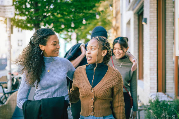Female couple talking while walking down the street.