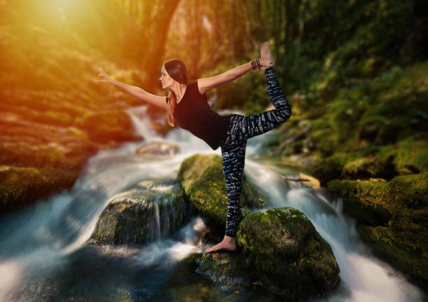 Woman doing yoga in the middle of a fast river, shot with long exposure