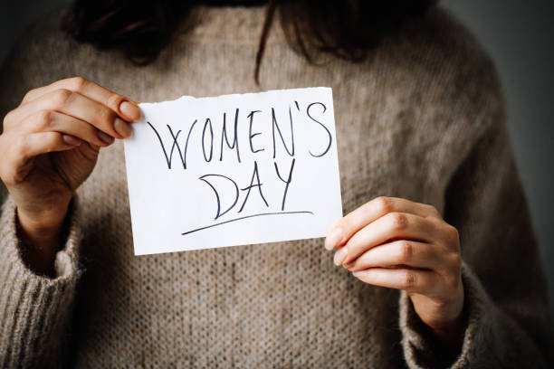 istock Woman with a note with the text womens day 1371516335