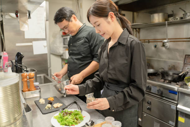 funcionários do sexo masculino e feminino servindo comida no restaurante - salad japanese culture japan asian culture - fotografias e filmes do acervo