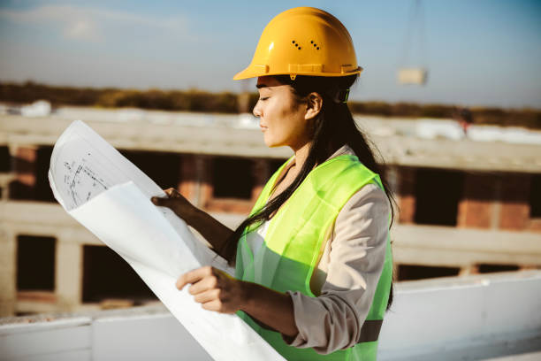 istock Female Civil Engineering Holding Blueprint on Construction Site 1371516550