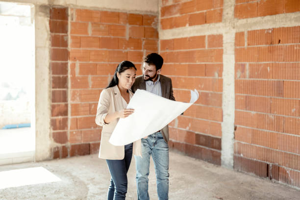 istock Mixed Race Couple Looking at Blueprints at the Construction Sites 1371517471