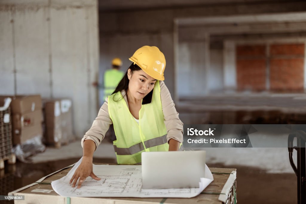 She always reviews every detail of her work Young Asian Engineers Woman Using Smartphone at the Construction Sites Construction Industry Stock Photo