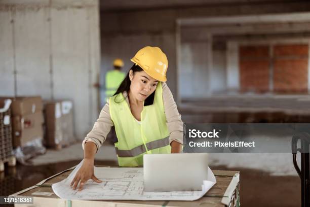 She Always Reviews Every Detail Of Her Work Stock Photo - Download Image Now - Construction Industry, Construction Site, Using Phone