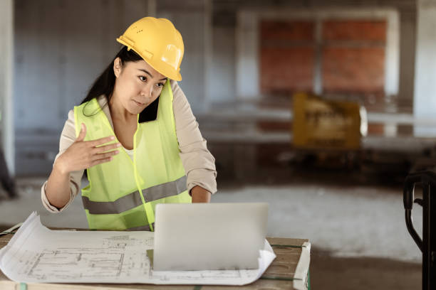 istock Asian Female Architect Manager Talking on Cellphone at Construction Sites 1371519182