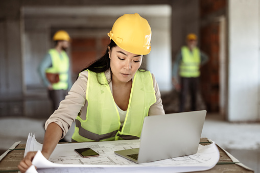 Young Confident Woman Drawing on Print Construction Project of the Building