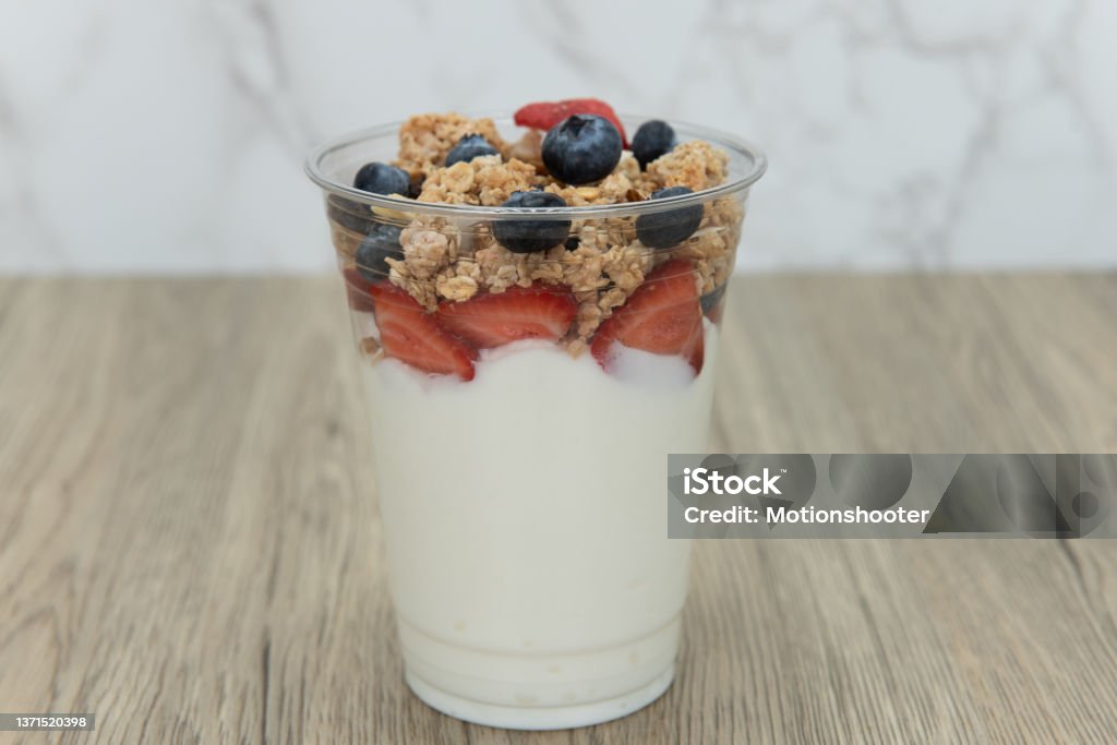 Quick snack to eat after a workout. Complete meal contained in this cup of yogurt, blueberries, strawberries, and granola for plenty of protein and carbohydrates to eat. Parfait Stock Photo