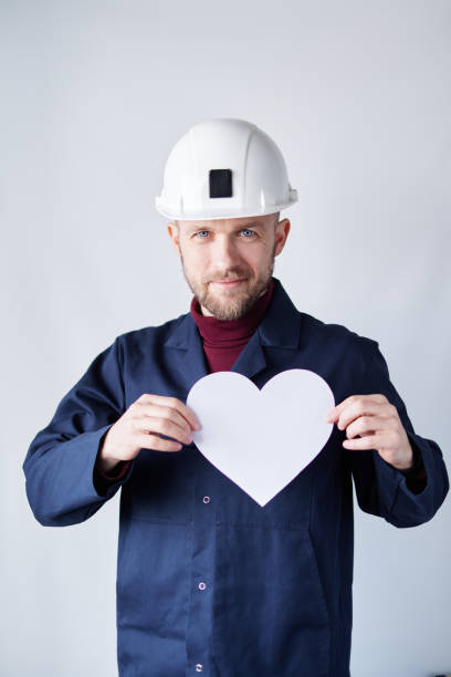 istock Labor Day concept: engineer in hard hat with white paper heart 1371522526