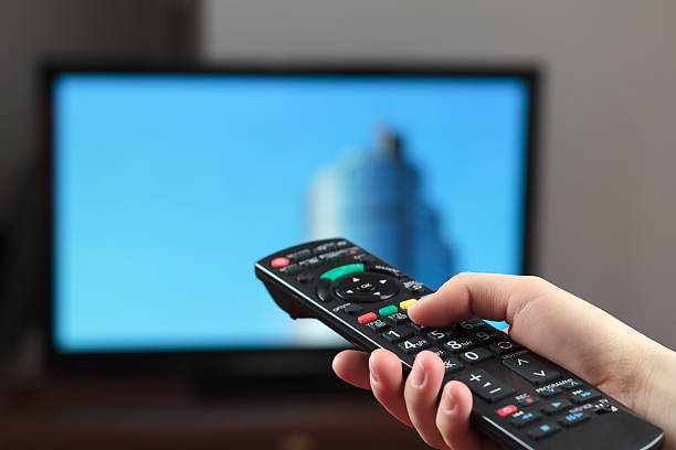 istock Hand holding a remote control with television in background 137152317
