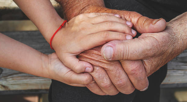 istock old man holding child's hands. selective focus 1371524773