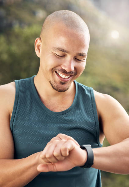 istock Shot of a young man checking his watch while out for a run 1371525669