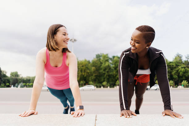 istock Two beautiful women making plank in city square during sport activity 1371526552