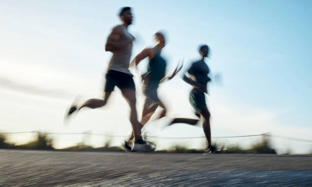 Blurred shot of three athletic young men running together