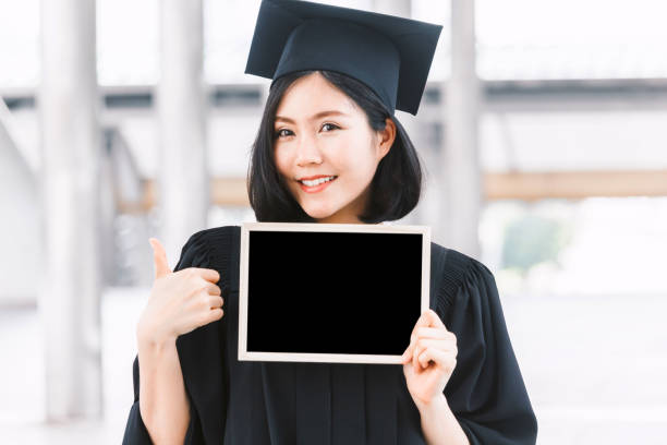 Woman students successful graduation holding empty blank board stock photo