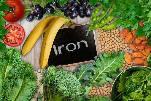 Plant based sources of iron background. broccoli, banana, tomatoes, almond, spinach, green peas, collards, grapes, kale, soya been and nuts are iron-rich foods.