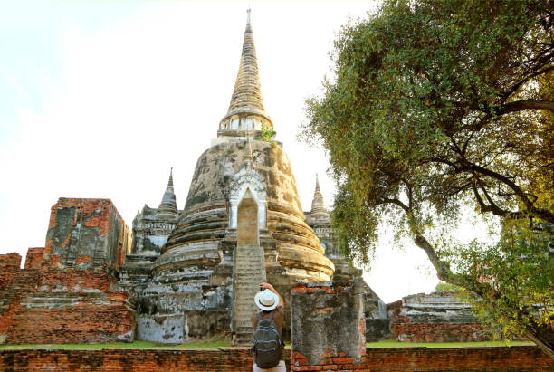 visiteur prenant des photos de la pagode historique du temple wat phra si sanphet et du palais royal, parc historique d’ayutthaya, thaïlande - sanphet palace photos et images de collection