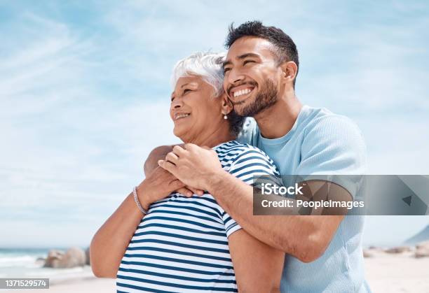 Shot Of A Young Man Spending The Day At The Beach With His Elderly Mother Stock Photo - Download Image Now