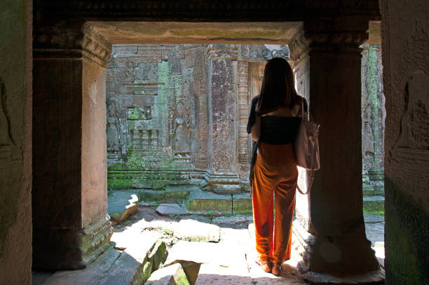 junge frau steht in kontemplation silhouette in steinmauer enthüllung, angkor wat, kambodscha, südostasien - cambodia traditional culture ancient angkor stock-fotos und bilder