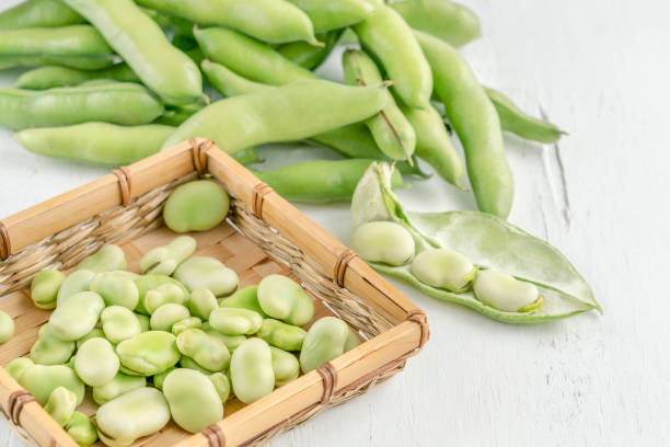 gros plan sur des graines de fèves fraîches sur une table en bois - fava bean photos et images de collection