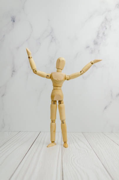 istock wooden mannequin in demonstration pose, raising his hands up, points to an empty space for text. 1371532678