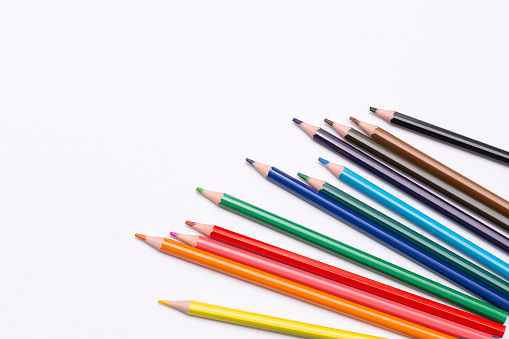 colored pencils are scattered on a light background. High quality photo