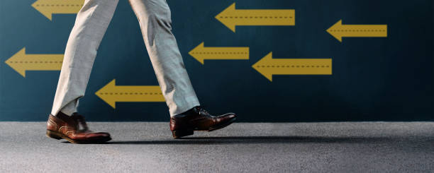 istock Think and Make the Different Concept. Unique Leadership. Businessman Walking Conversely the Arrow Direction. Different from Others. Low Angle View 1371536842