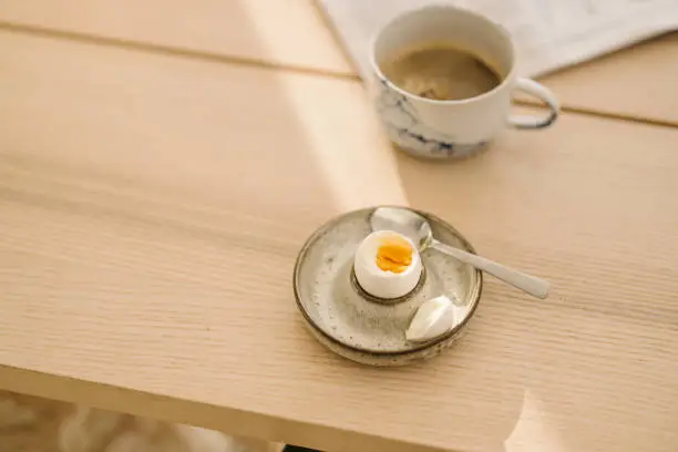Egg in eggcup for breakfast simple photo
Photo taken indoors on table in natural sunlight no people