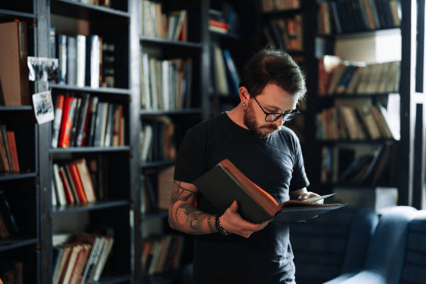 istock Adult student reading a book in the college library 1371537701