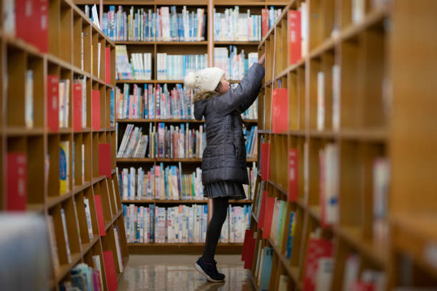 garota escolhendo um livro - bookstore library book bookshelf - fotografias e filmes do acervo