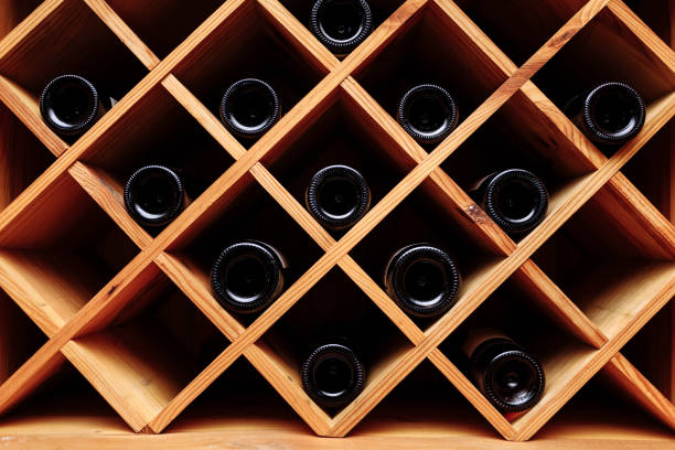 istock Wine bottles stacked on wooden racks. Vintage effect. 1371540160