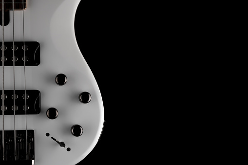 Headstock of an electric guitar on black background.