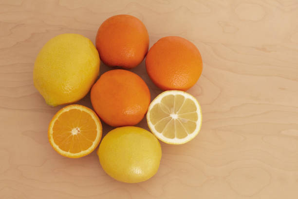 fresh citrus lemons and oranges are grouped on a wooden table. some of them are cut and its juice is visible. perfect aroma and vitamins. its color is a great antidepressant