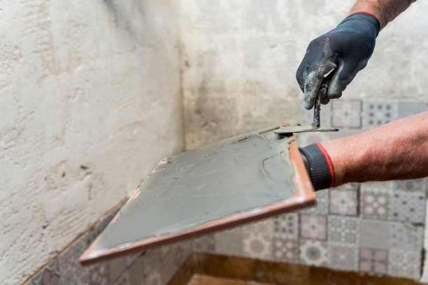 istock Close up Senior Man Hands Applying Adhesive on Tile 1371542089