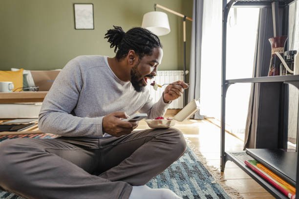 istock Eating take away meal at home and using mobile phone 1371543585