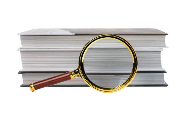 istock Books stack and magnifying glass isolated on white background. Information search and analysis 1371547020