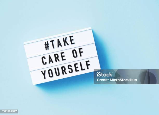 Take Care Of Yourself Written White Lightbox Sitting On Blue Background Stock Photo - Download Image Now