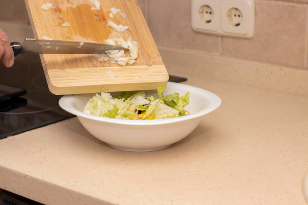 Pour the cut onion from a cutting board. Selective focus.