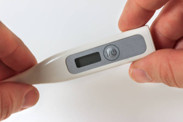 istock Caucaisan man is holding digital thermometer in his hand on white background. 1371547639