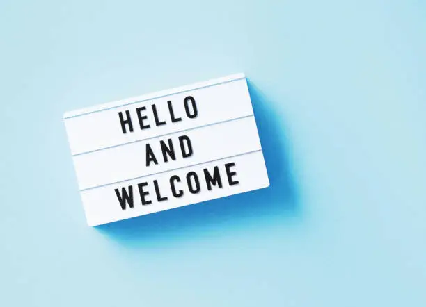 Photo of Hello And Welcome Written White Lightbox Sitting On Blue Background