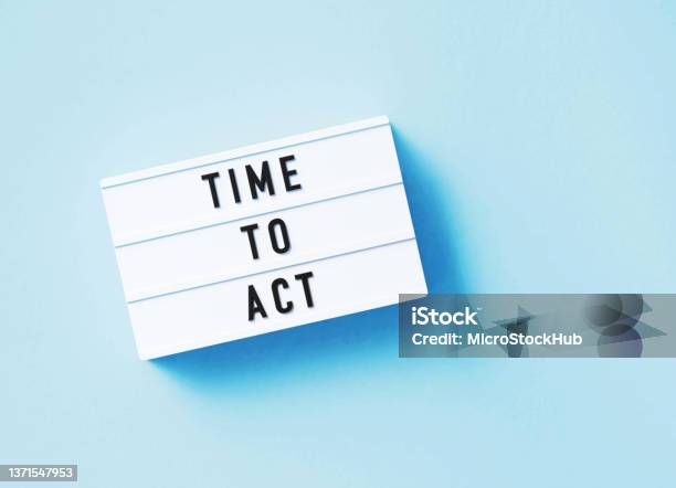 Time To Act Written White Lightbox Sitting On Blue Background Stock Photo - Download Image Now