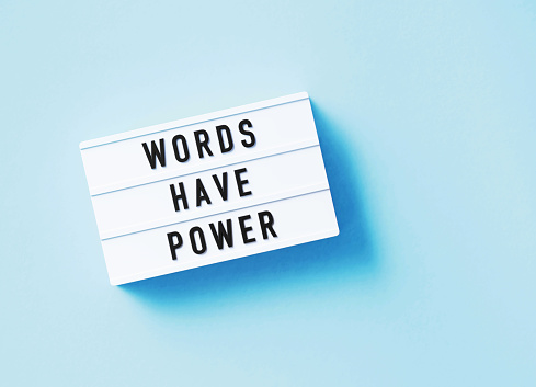 Words have power written white lightbox sitting on blue background. Horizontal composition with copy space.