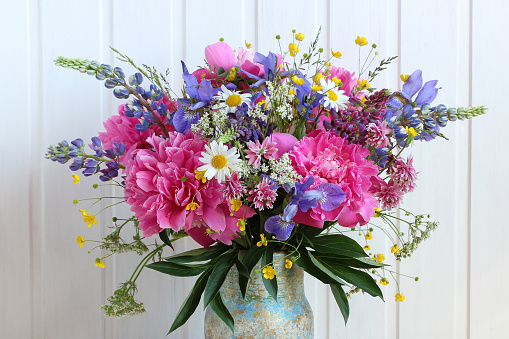 bright bouquet of peonies, buttercups, lupines, daisies and other flowers as a floral background.