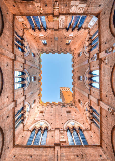 Siena from low A view of the palazzo pubblico in Siena, Tuscany torre del mangia stock pictures, royalty-free photos & images