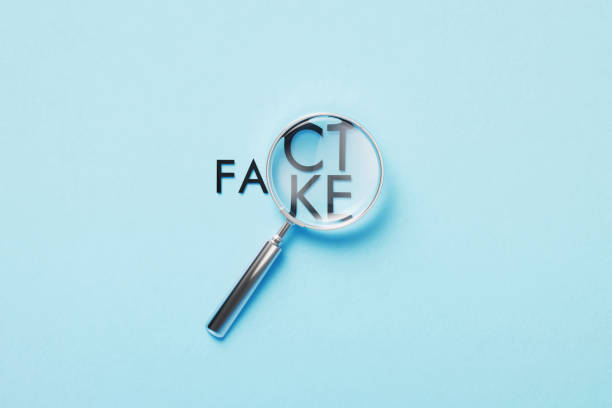 magnifier over fact or fake words on blue background - imitação imagens e fotografias de stock