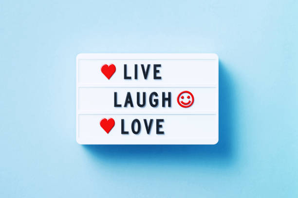 Live laugh love written white lightbox sitting on blue background. Horizontal composition with copy space.